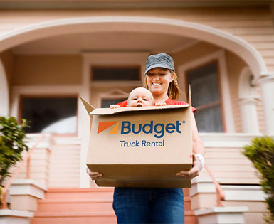 Happy mom moving with baby in Budget Truck boxes Happy mom moving with baby in Budget Truck boxes