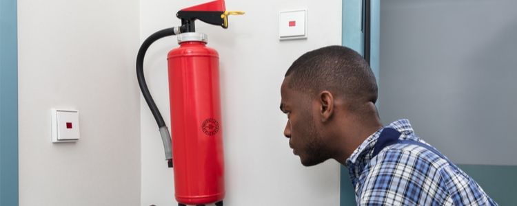 Man testing fire extinguisher for daylight savings time Man testing fire extinguisher for daylight savings time