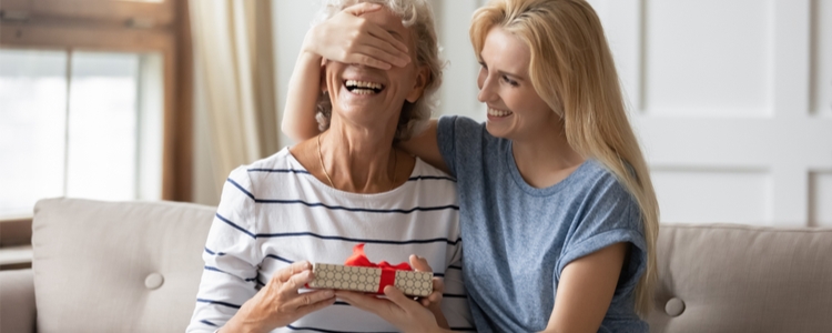 Happy daughter giving mom union-made present. Happy daughter giving mom union-made present.